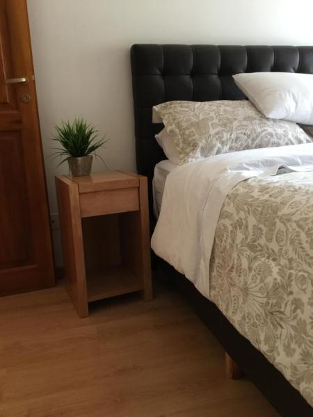 Un dormitorio con una cama y una mesa con una planta. en Departamento victoria en San Martín de los Andes