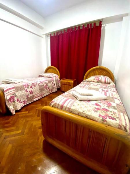 2 camas en una habitación con cortina roja en Flat in the heart of Mendoza en Mendoza