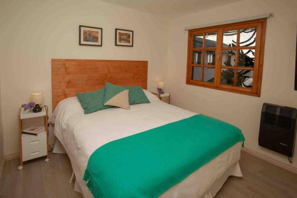 Un dormitorio con una cama grande y una ventana en Departamento 4 Personas centro SMA en San Martín de los Andes