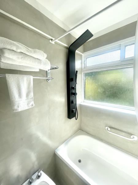 baño con bañera, aseo y ventana en Golf Tower Suites & Apartments en Buenos Aires