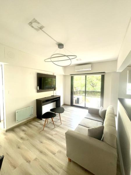 sala de estar con sofá y escritorio en Golf Tower Suites & Apartments en Buenos Aires