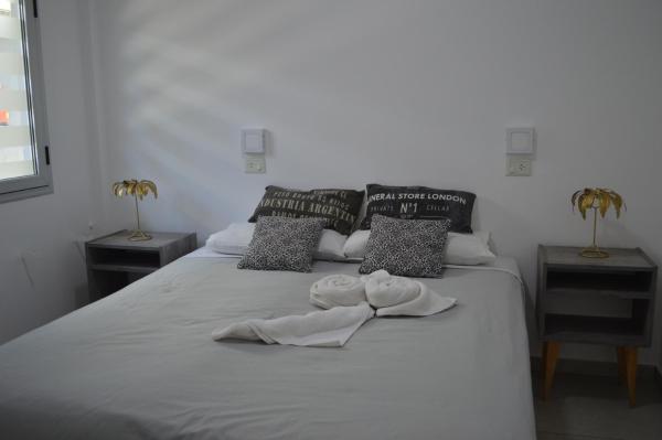 1 cama con 2 almohadas y toallas en Apart Hotel Verona en Puerto Madryn