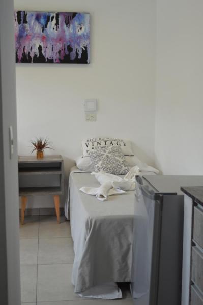 1 dormitorio con 1 cama, 1 mesa y 1 pintura en Apart Hotel Verona en Puerto Madryn