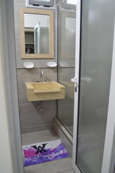 y baño con lavabo y espejo. en Apart Hotel Verona en Puerto Madryn