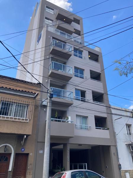 un edificio alto con un coche aparcado delante de él en Departamento 1 dormitorio a estrenar en Salta