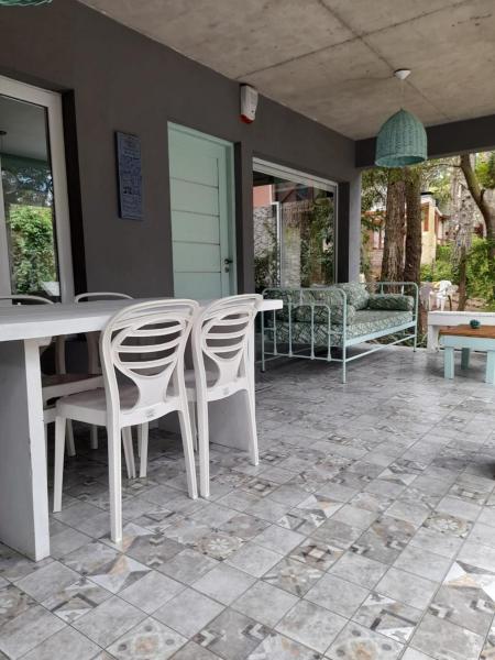 un patio con 2 sillas blancas y una mesa en Pampa y Cielo en Balneario Mar Azul