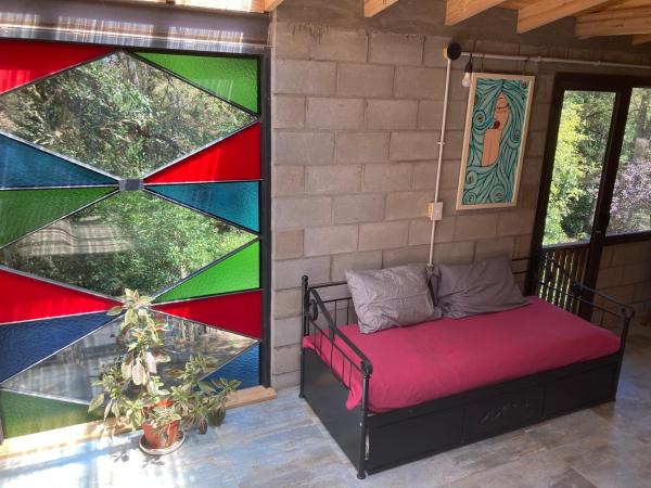 un porche con una cama colgada de la pared en Casa Trina en San Martín de los Andes
