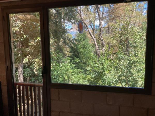 una ventana en una puerta con vistas a los árboles en Casa Trina en San Martín de los Andes