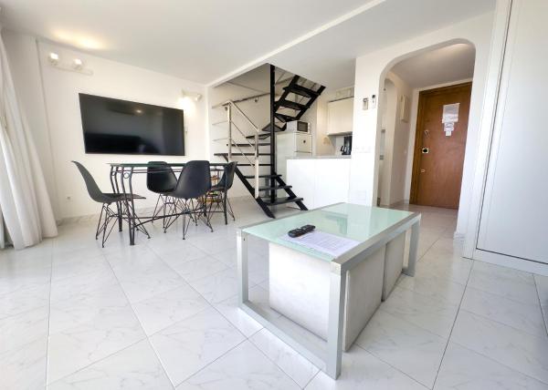 una sala de estar blanca con mesa y sillas en Skol 514 East Facing Duplex Apartment with Sea Views, en Marbella