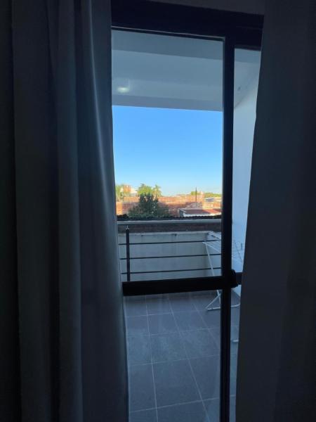 Habitación con ventana y vistas a un balcón. en Departamentos Céntricos Modernos - Pagos en USD - Consultar Disponibilidad por Teléfono en Gualeguaychú