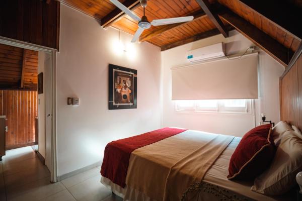 1 dormitorio con 1 cama en una habitación con ventana en Palma Real Bungalow en Puerto Iguazú