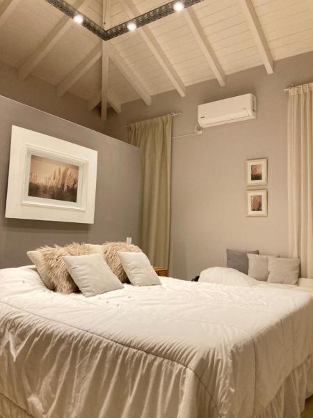 1 dormitorio con 1 cama grande con sábanas blancas en HERMOSA CASA CAMPO, EL MEJOR PAISAJE DE SALTA en Salta