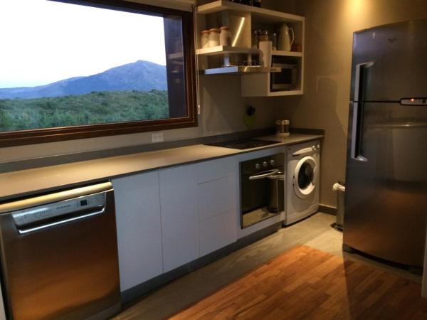 cocina con refrigerador de acero inoxidable y ventana a Terrazas del Pol en San Carlos de Bariloche