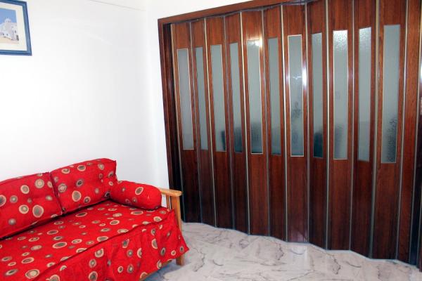 sala de estar con sofá rojo y puerta de madera en Apart Obelisco en Buenos Aires