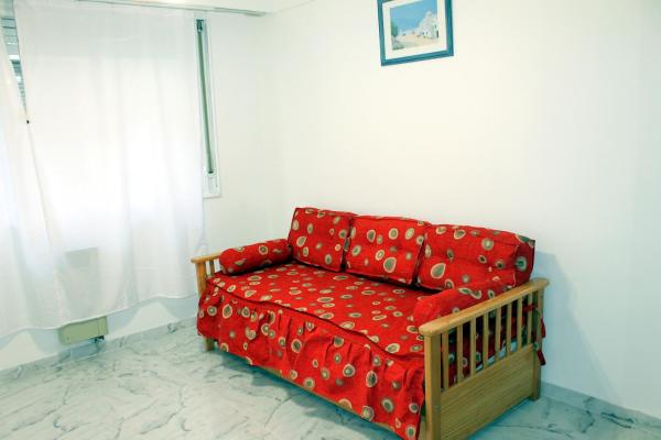 un sofá rojo sentado en una sala de estar en Apart Obelisco en Buenos Aires