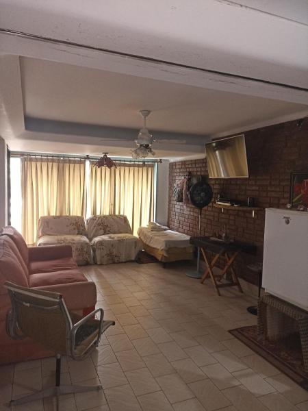 sala de estar con sofá y silla en "C" SPACIO HOSTEL - Habitación Compartida- en Mendoza