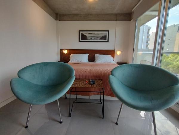 2 sillas azules en un dormitorio con cama en Estudio en Palermo para Dos Personas II en Buenos Aires