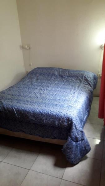 Cama en habitación con edredón azul en turismo chascomus en Chascomús