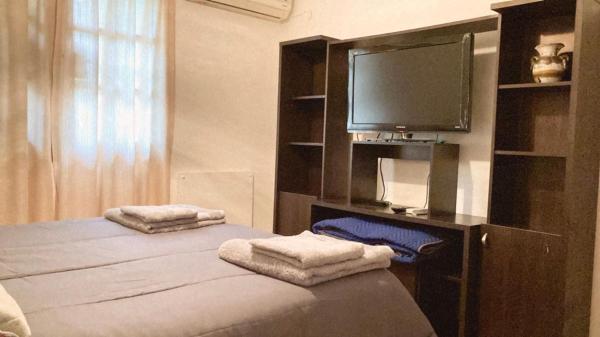 1 dormitorio con 1 cama, TV y toallas en Paz y armonía cerca de todo en San Salvador de Jujuy