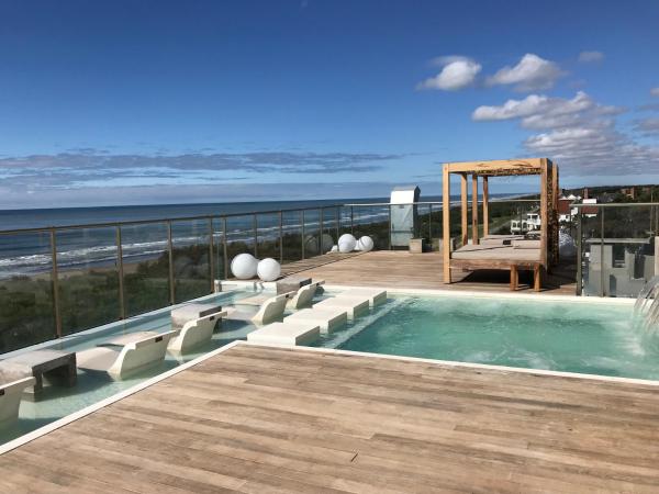 una piscina en una terraza con el océano en el fondo en Almarena Apart & Hotel Boutique en Costa del Este