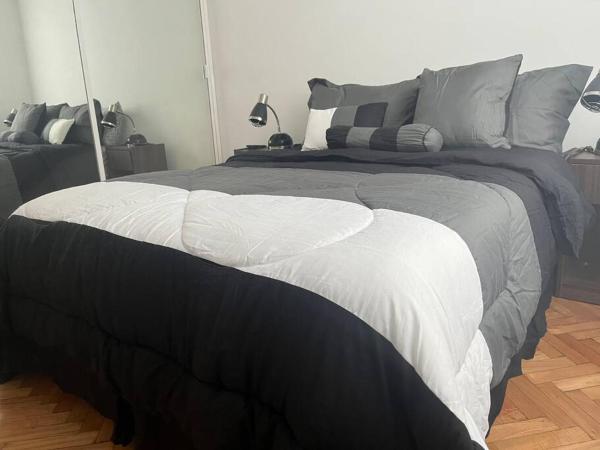 1 dormitorio con 1 cama grande en blanco y negro en Departamento 2 AMB con amenities en Buenos Aires
