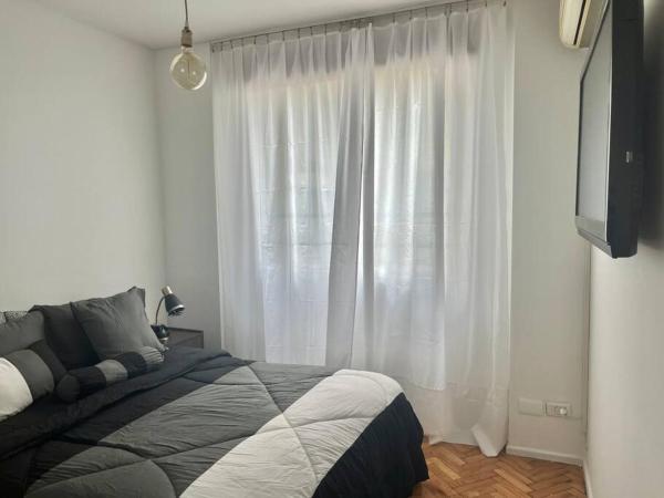 1 dormitorio con 1 cama y una ventana con cortinas blancas en Departamento 2 AMB con amenities en Buenos Aires