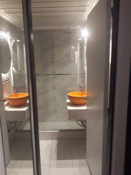 2 lavabos en un baño con tazones naranjas en Departamento frontal en Planta Baja, frente a plaza independencia en Mendoza