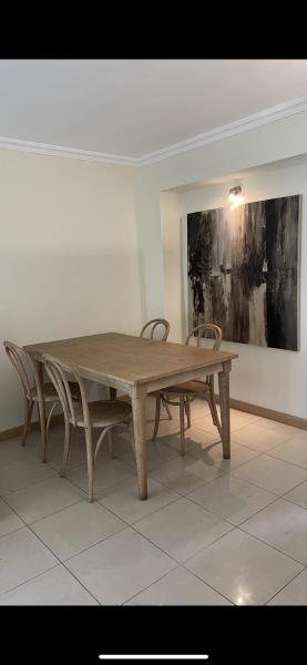 una mesa de madera y sillas en una habitación en Departamento luminoso, Capital Mendoza en Mendoza
