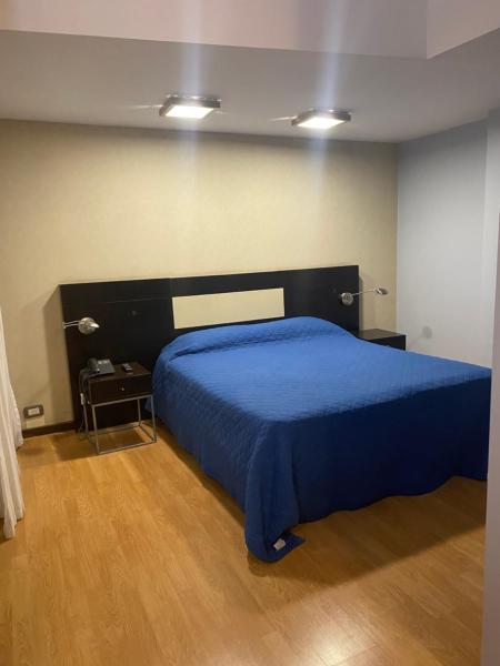 1 dormitorio con 1 cama con colcha azul en Urban en San Juan