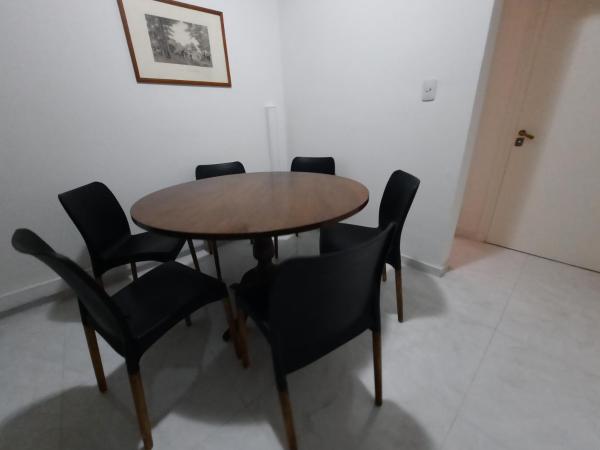 una mesa de comedor con sillas negras alrededor en Departamento Céntrico San Juan en San Juan