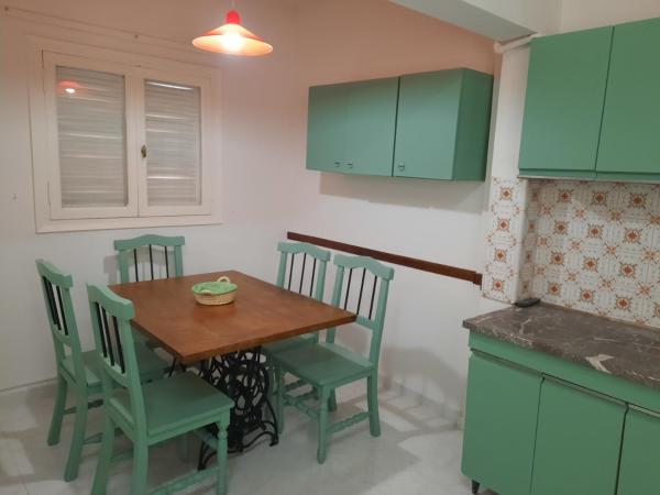 una cocina con armarios verdes y una mesa y sillas de madera. en Departamento Céntrico San Juan en San Juan