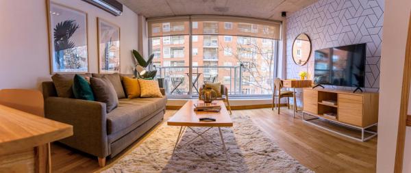 sala de estar con sofá y TV en Disfruta este Increíble y Unico Depto @BuenosAires - 402 - en Buenos Aires