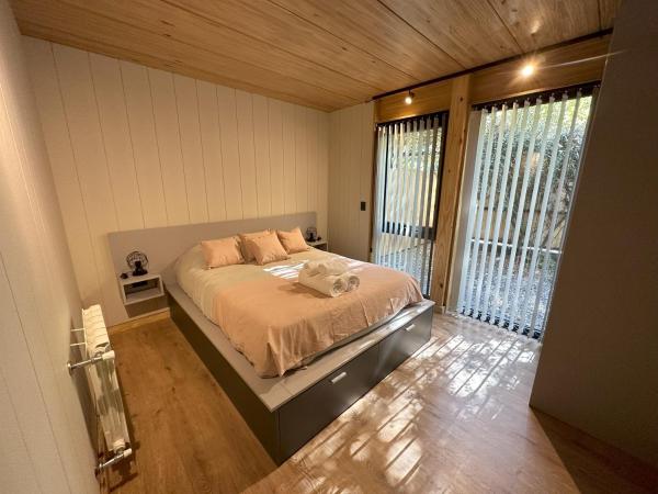 1 dormitorio con cama y ventana grande en Hermoso departamento de 3 ambientes con amplio jardin. 1V5 en San Martín de los Andes