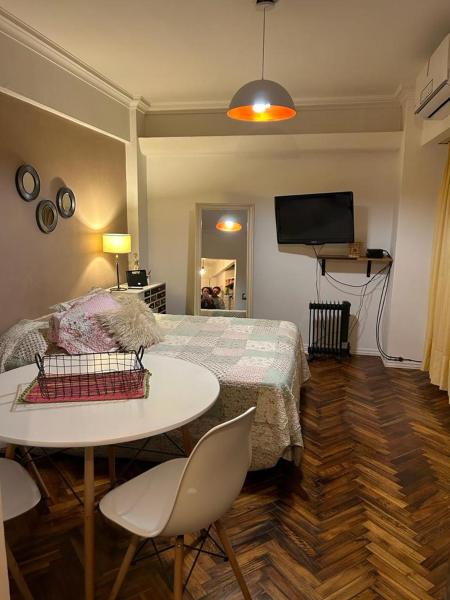 1 dormitorio con cama, mesa y TV en Departamento Impecable en Balvanera en Buenos Aires