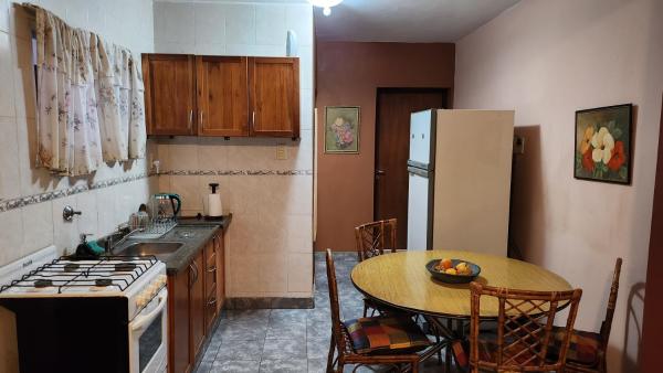 una pequeña cocina con mesa y refrigerador en LO DE LALY en Salta