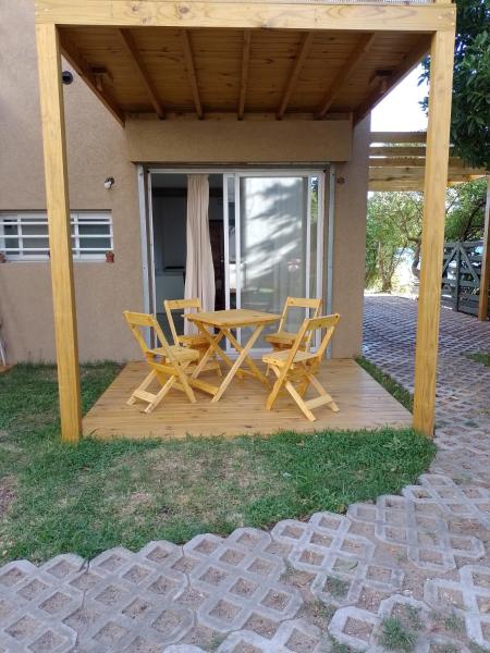 una terraza de madera con mesa y sillas. en Tiké en Ostende