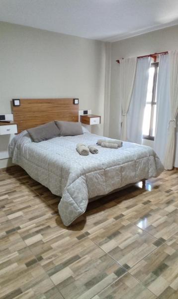 1 dormitorio con 1 cama con 2 toallas en Loft/Apart Michel Iguazu en Puerto Iguazú