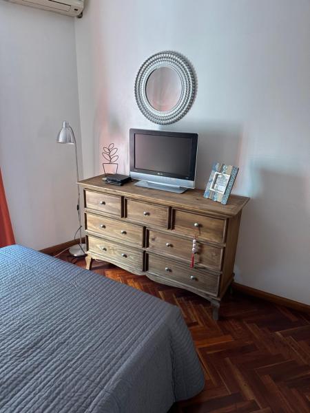 Un dormitorio con un tocador con TV. en Apartamento Semipiso en la mejor zona de Belgrano todo al frente con parking privado y a metros del Subway 2 habitaciones Parrrilla Solarium Cocina amplia Lavadero y mobiliario todo a nuevo en Buenos Aires