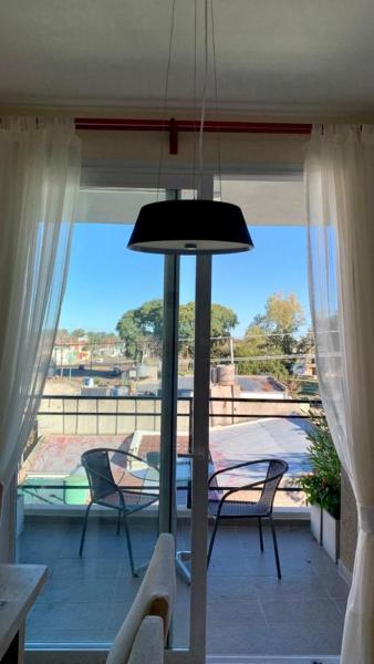 Habitación con vistas a un balcón con mesa y sillas. en Monoambiente muy luminoso en Gualeguaychú