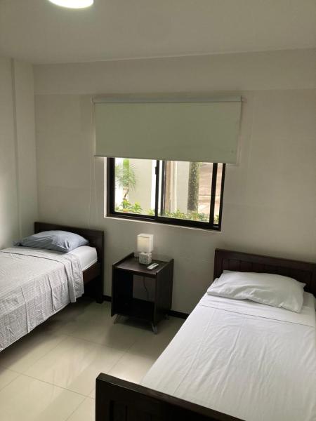 1 dormitorio con 2 camas, ventana y mesa en Departamento Planta Baja con parqueo en Condominio, en Santa Cruz de la Sierra