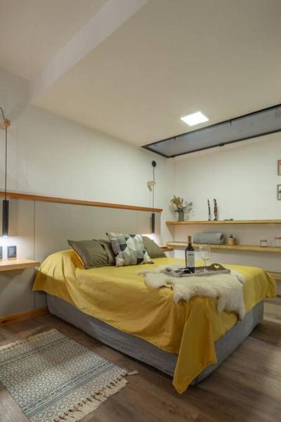 1 dormitorio con 1 cama grande con manta amarilla en Brand new - Cozy Apartment- En el corazon de Mendoza en Mendoza