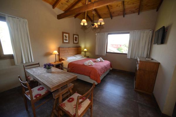 1 dormitorio con 1 cama, mesa y sillas en La Morada Apart Boutique en Villa Gesell