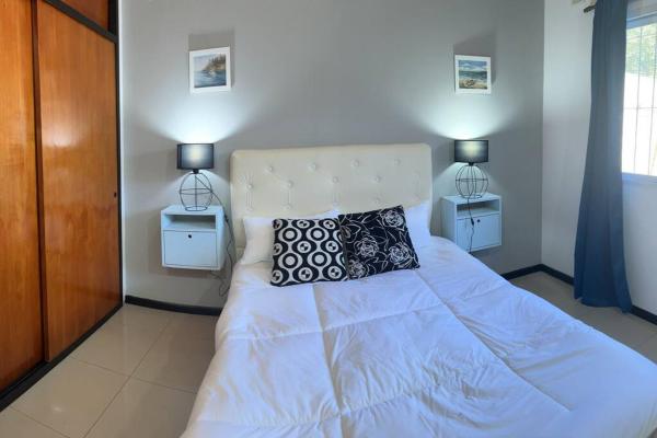 1 dormitorio con 1 cama blanca y 2 mesitas de noche en Asombroso departamento en CABA con patio en Buenos Aires