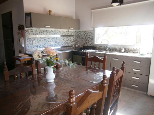 una cocina con una mesa con un jarrón de flores. en Vacaciones en Belgrano VP en Villa General Belgrano