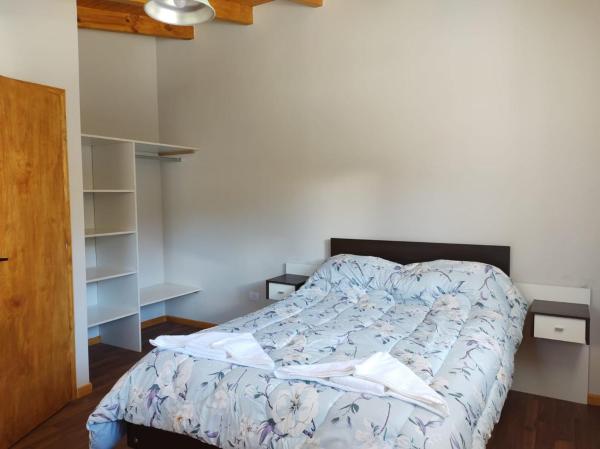 1 dormitorio con 1 cama con edredón azul en "Antúbea" Departamento particular en San Martín de los Andes