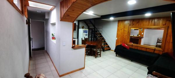 sala de estar con sofá y escalera en "Antúbea" Departamento particular en San Martín de los Andes