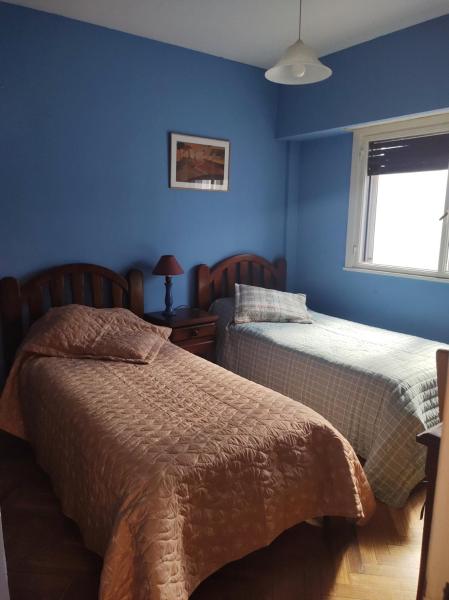 2 camas en un dormitorio con paredes azules en Excelente depto 3 ambientes en Buenos Aires