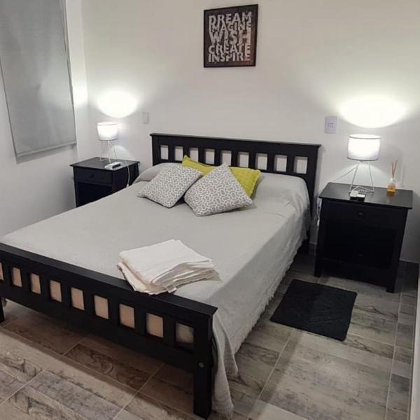 1 dormitorio con 1 cama grande y 2 mesitas de noche en La Cabrera Salta en Salta