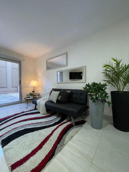 1 dormitorio con cama, sofá y alfombra en DEPTO CASEROS en Salta