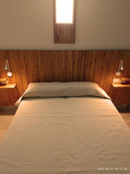 Un dormitorio con una cama con paredes de madera y una ventana en Tiké en Ostende